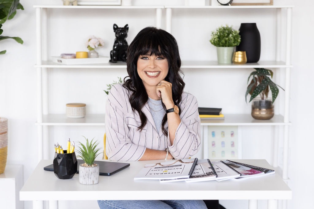 B Wyrick of The Wyrick Outlook seated at her studio desk