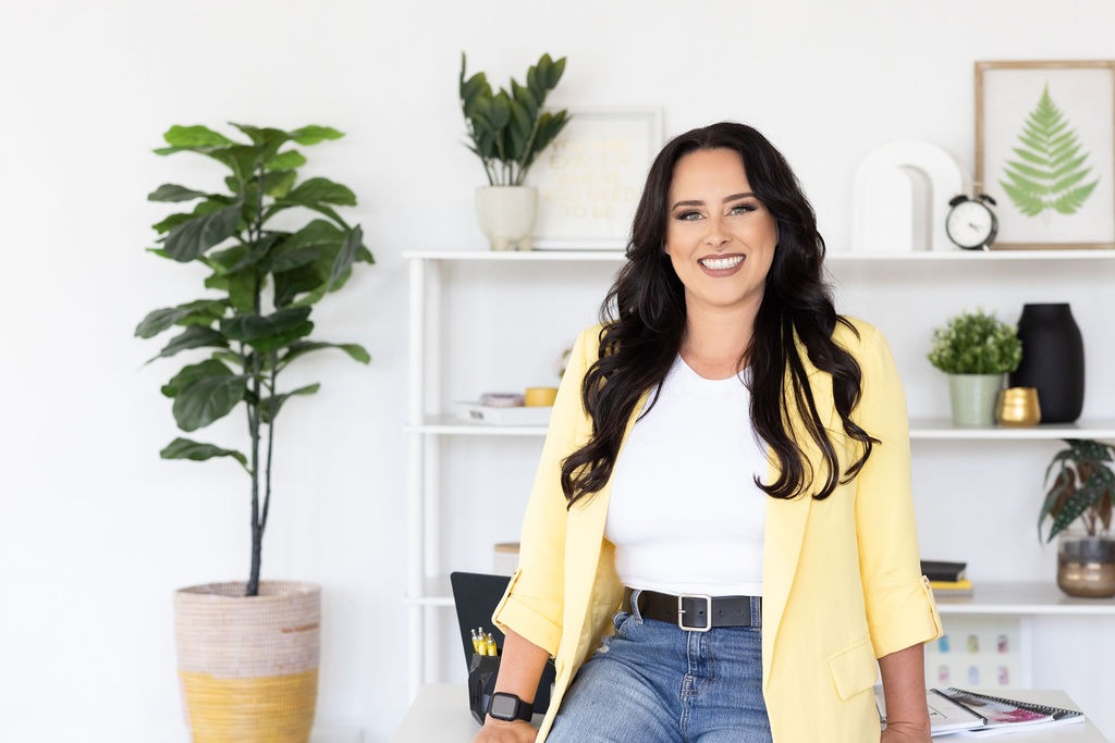Megan Wyrick of The Wyrick Outlook seated on a stool in her studio office